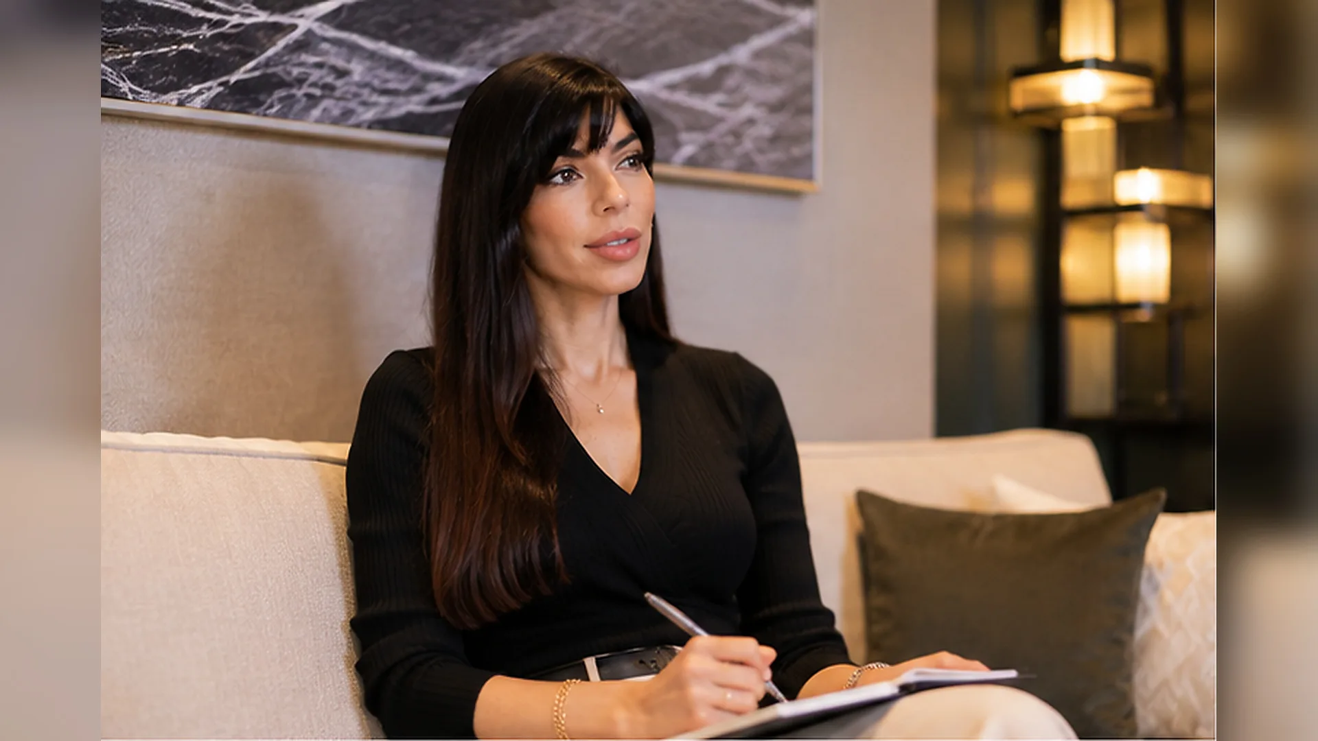 Rima Iskandarani preparing for an event in a lounge, reviewing the run of show in a black top