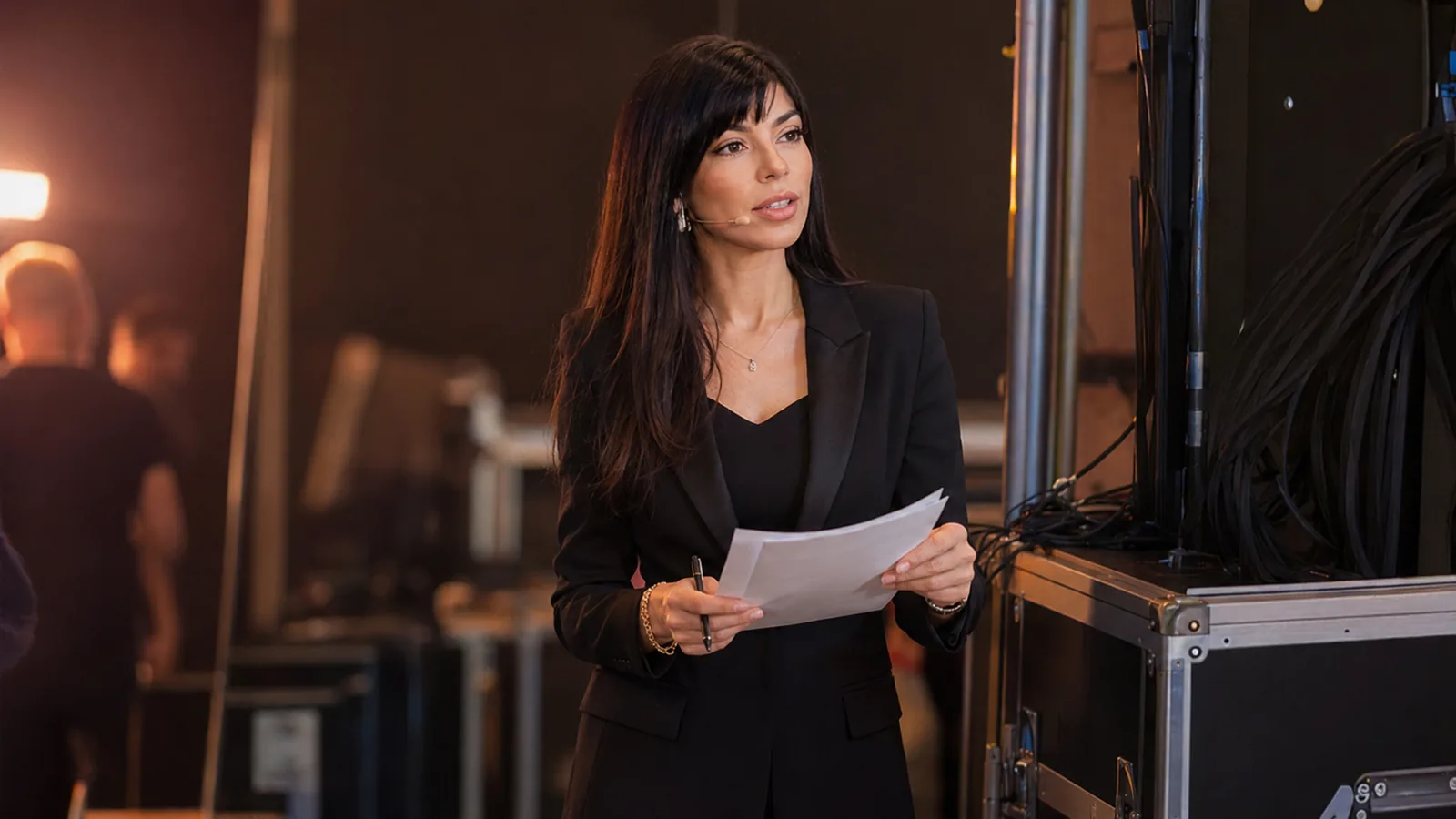 Rima Iskandarani preparing backstage with cue sheets before a live event